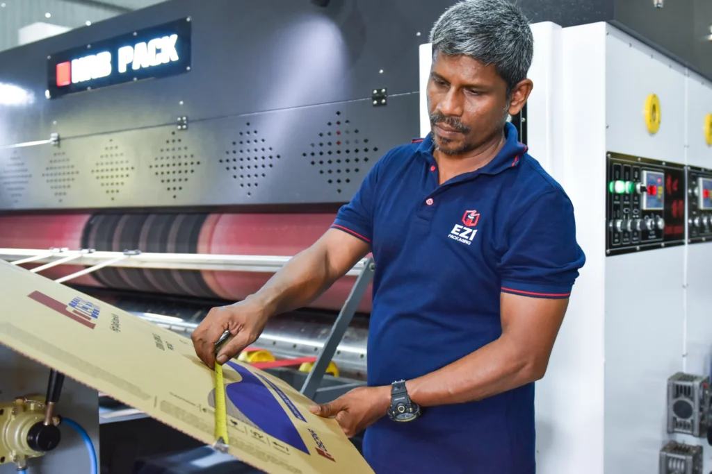 EZI Packaging worker measuring corrugated cardboard box during manufacturing process in Sri Lanka