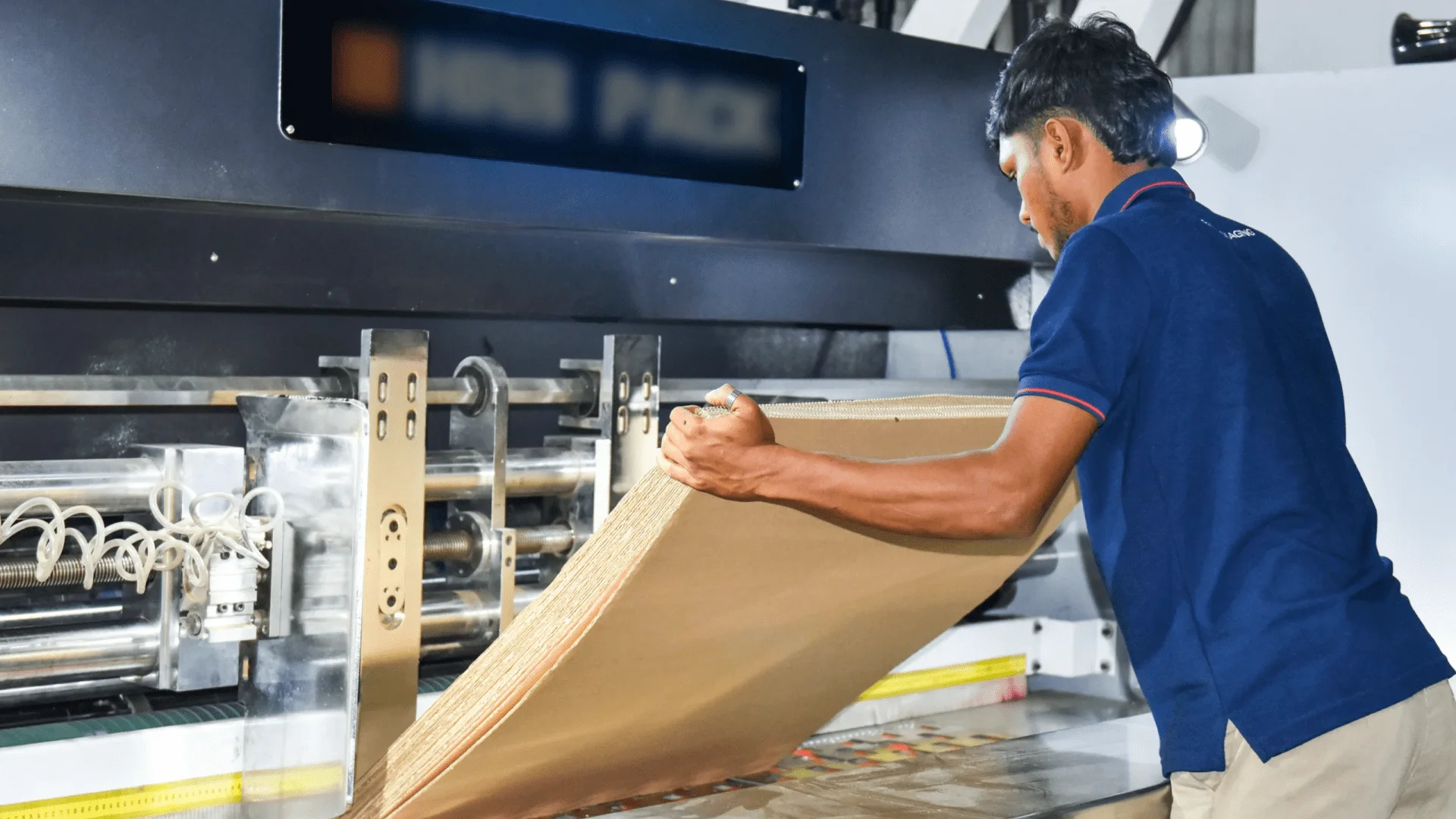 EZI team member feeding sheets of material into a processing machine