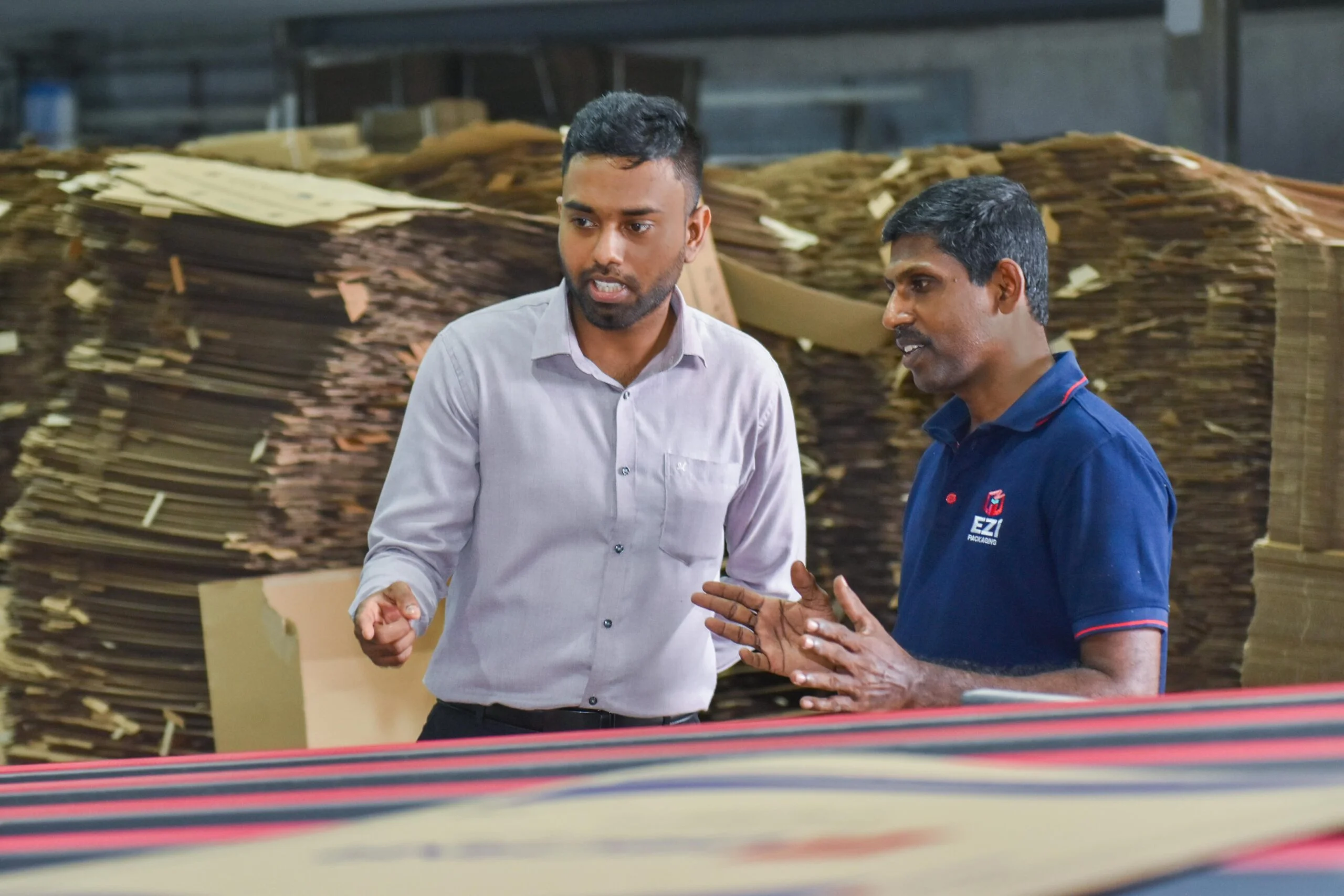 EZI Packaging team discussing corrugated packaging production process inside Sri Lanka factory